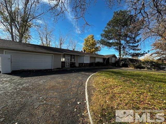 ranch-style home with a garage and a front lawn