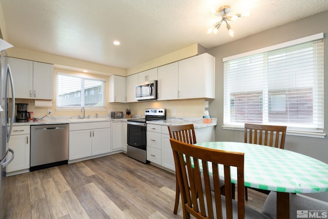 kitchen with a healthy amount of sunlight, white cabinets, and stainless steel appliances