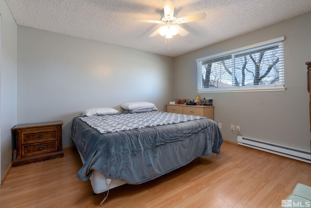 bedroom featuring a textured ceiling, light hardwood / wood-style floors, a baseboard radiator, and ceiling fan