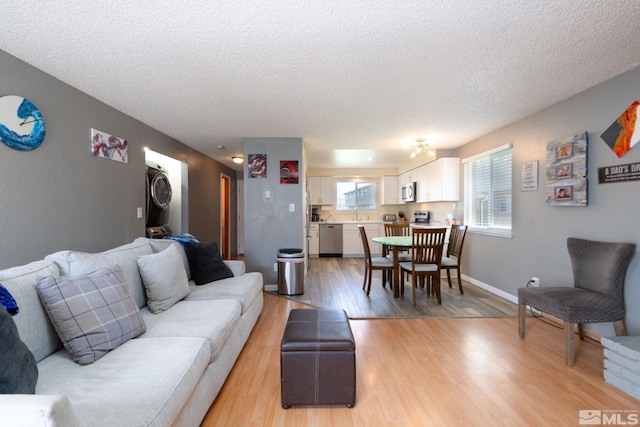 living room with light wood-type flooring and a textured ceiling