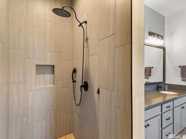 bathroom featuring a tile shower and vanity