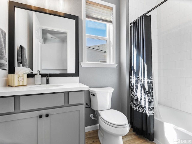 full bathroom featuring toilet, hardwood / wood-style floors, vanity, and shower / tub combo with curtain