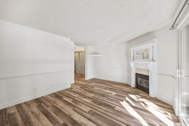 unfurnished living room featuring a textured ceiling and hardwood / wood-style flooring