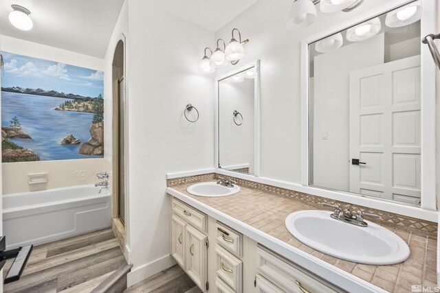 bathroom with hardwood / wood-style floors, vanity, and shower with separate bathtub