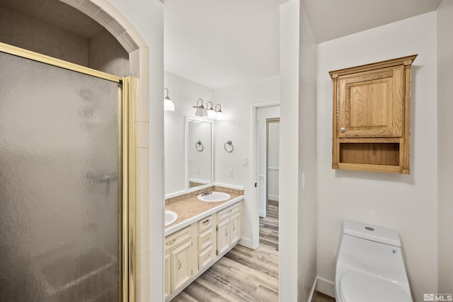 bathroom featuring toilet, a shower with door, vanity, and hardwood / wood-style flooring