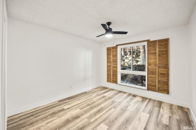 unfurnished room featuring a textured ceiling and light hardwood / wood-style flooring