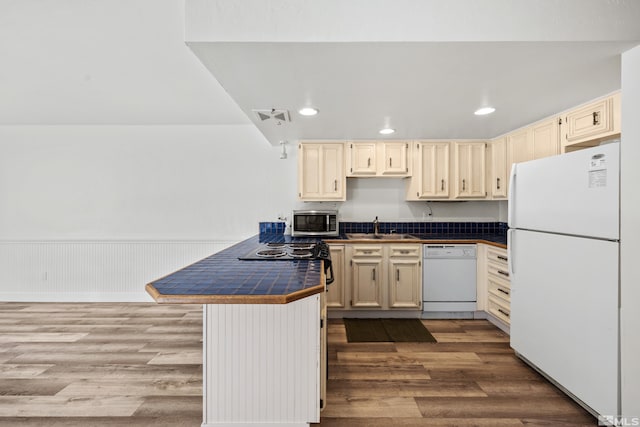 kitchen featuring sink, tile counters, white appliances, cream cabinetry, and light wood-type flooring