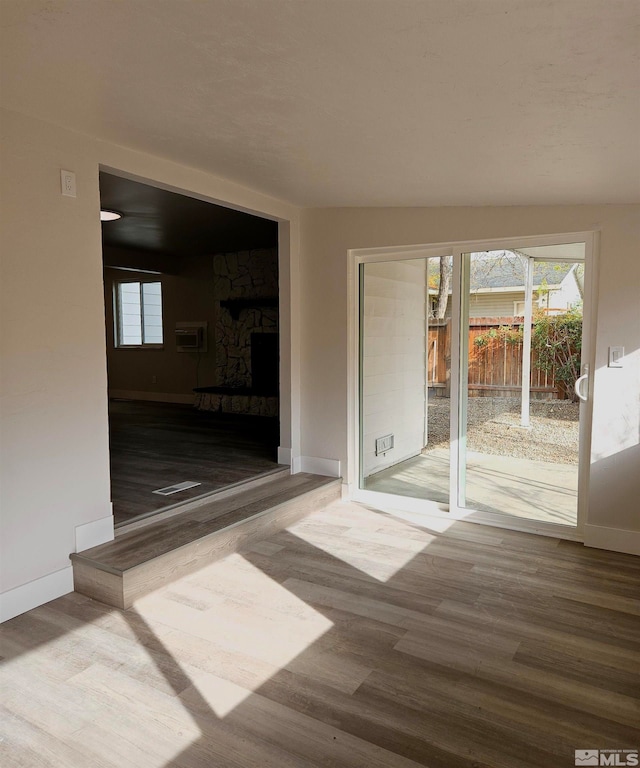 empty room featuring hardwood / wood-style floors, lofted ceiling, and a fireplace