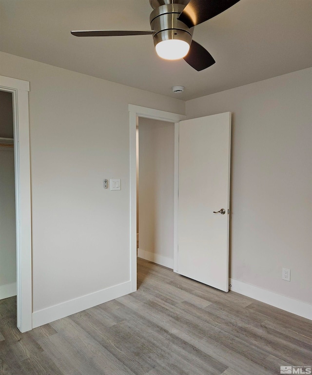 unfurnished bedroom featuring a closet, light hardwood / wood-style flooring, and ceiling fan