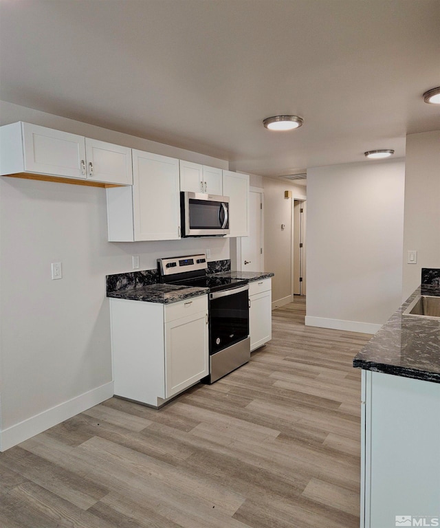 kitchen featuring white cabinets, stainless steel appliances, and light wood-type flooring