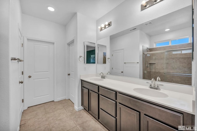 bathroom with tile patterned flooring, vanity, and a shower with shower door