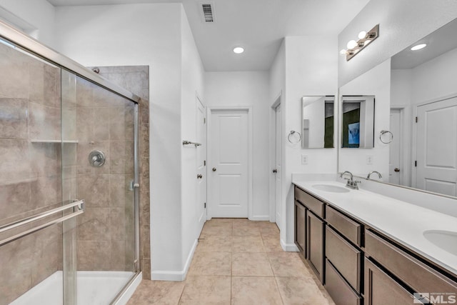 bathroom with tile patterned floors, vanity, and a shower with shower door