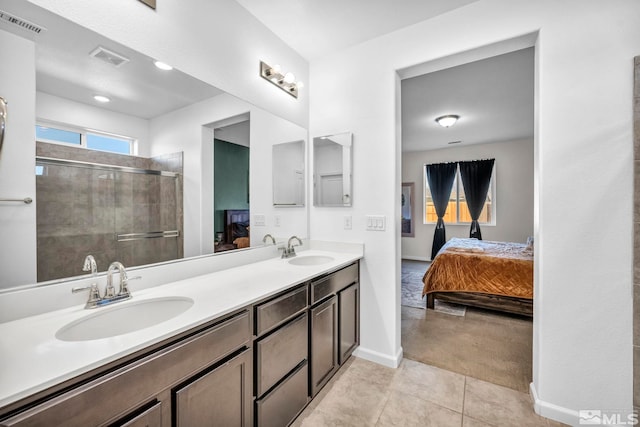 bathroom featuring tile patterned flooring, vanity, and a shower with shower door