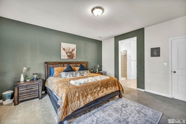 bedroom with ensuite bath and carpet floors