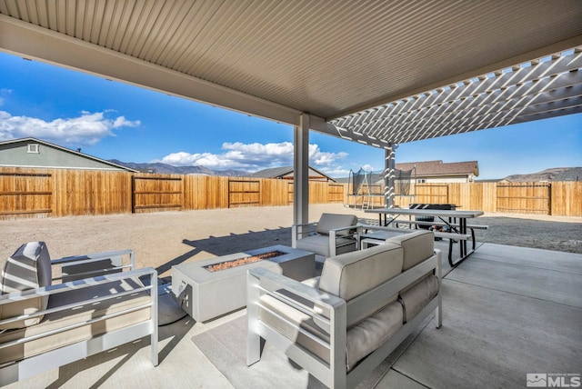 view of patio / terrace with a mountain view and a fire pit