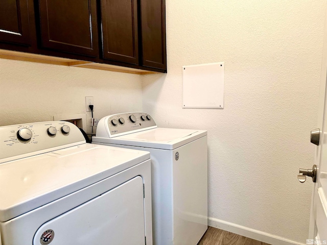 washroom featuring cabinets, independent washer and dryer, and hardwood / wood-style flooring