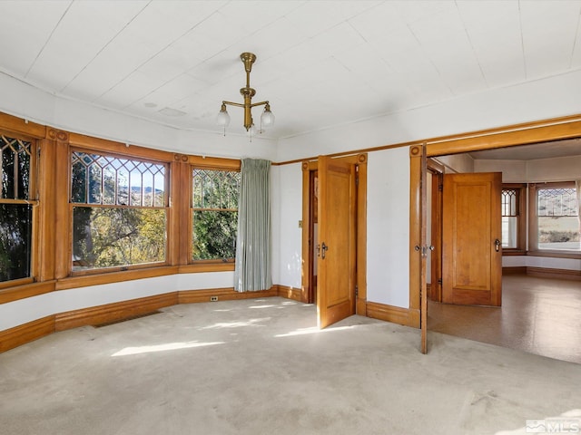 unfurnished bedroom featuring a chandelier and multiple windows