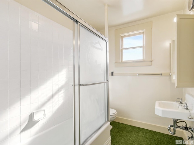 bathroom with combined bath / shower with glass door and toilet