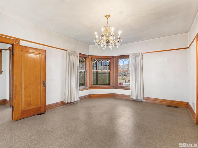 unfurnished room featuring a chandelier