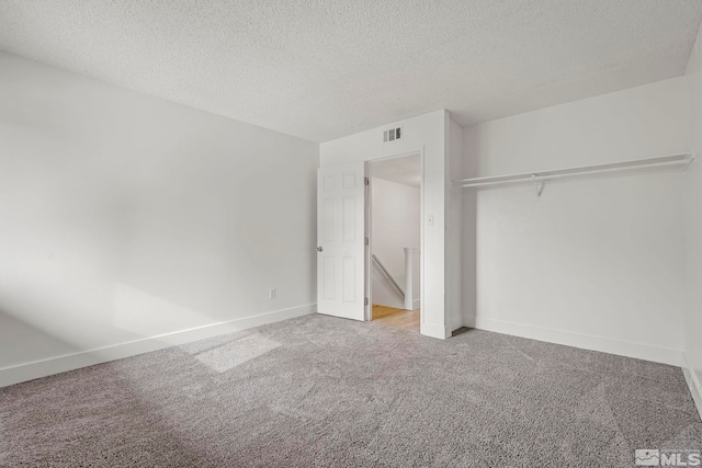 unfurnished bedroom featuring carpet, a textured ceiling, and a closet