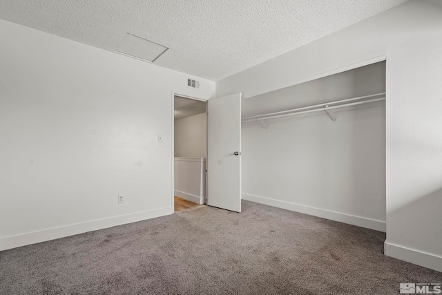 unfurnished bedroom with carpet flooring, a textured ceiling, and a closet