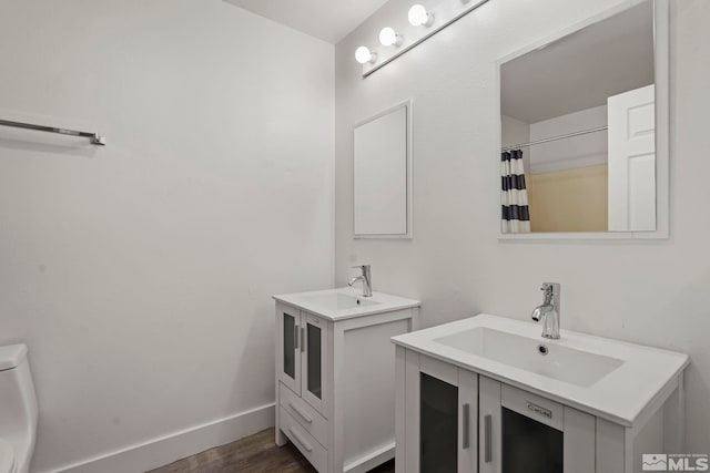 bathroom with a shower with shower curtain, hardwood / wood-style floors, vanity, and toilet