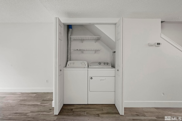 laundry area with hardwood / wood-style flooring, independent washer and dryer, and a textured ceiling