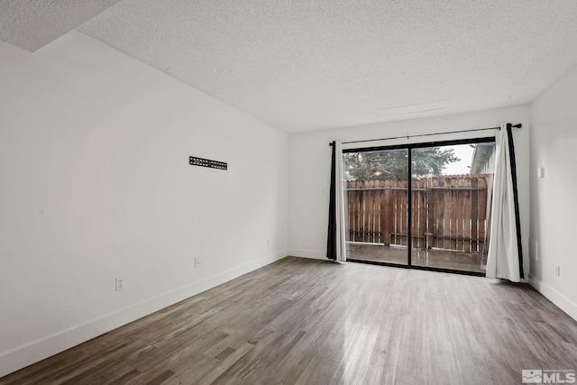 spare room featuring a textured ceiling and hardwood / wood-style flooring