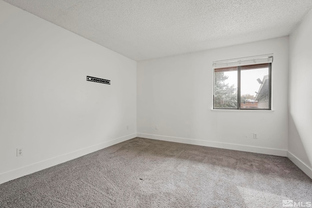 empty room with a textured ceiling and carpet floors