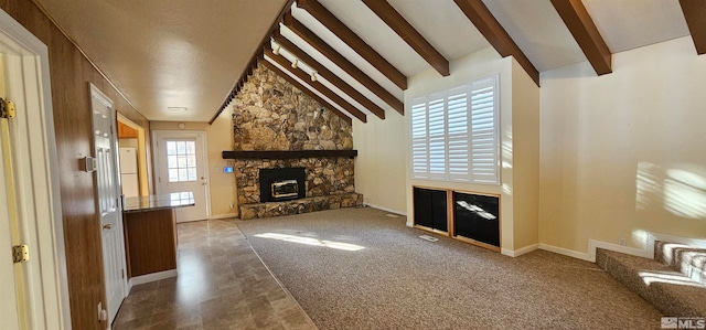 unfurnished living room featuring carpet, a fireplace, beamed ceiling, and high vaulted ceiling