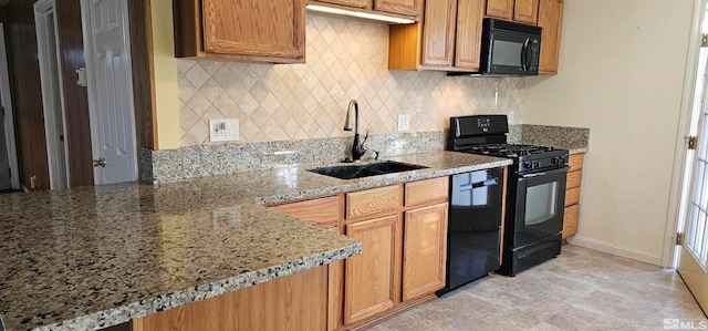 kitchen with black appliances, backsplash, light stone countertops, and sink