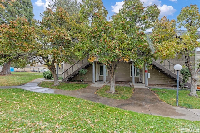 obstructed view of property with a front lawn