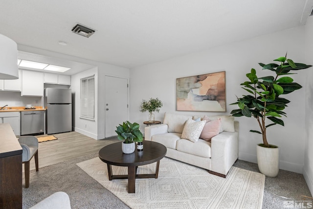 living room with light wood-type flooring and sink