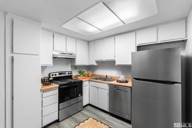 kitchen with sink, white cabinets, light hardwood / wood-style flooring, and appliances with stainless steel finishes