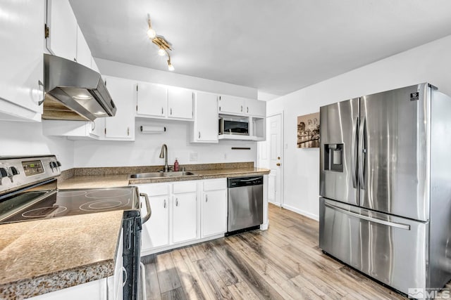 kitchen with appliances with stainless steel finishes, sink, exhaust hood, light hardwood / wood-style floors, and white cabinetry