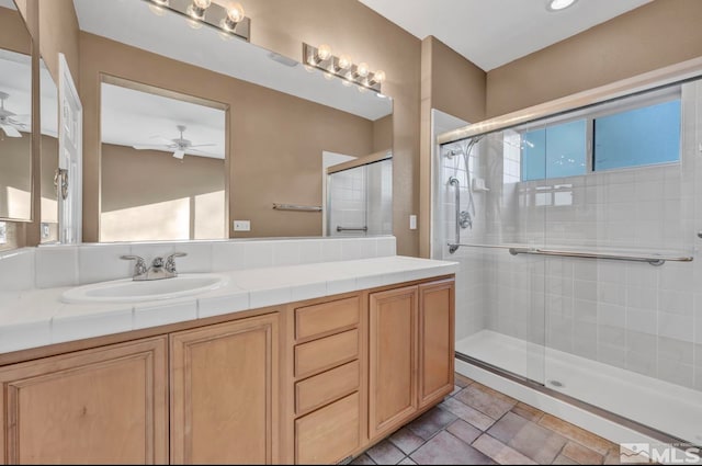 bathroom featuring ceiling fan, vanity, and a shower with shower door