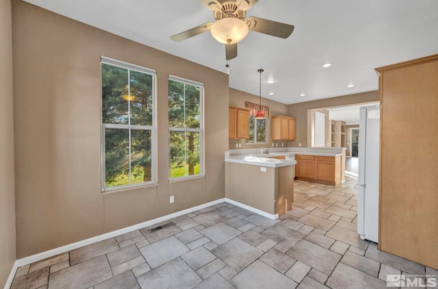 kitchen featuring ceiling fan, light brown cabinets, sink, kitchen peninsula, and white fridge