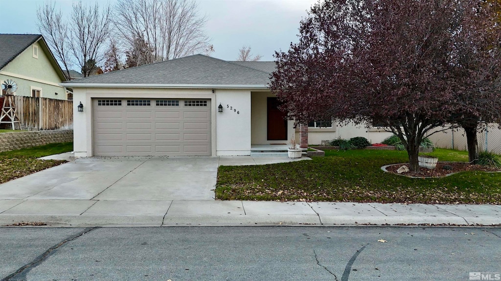 view of front of home with a front yard and a garage