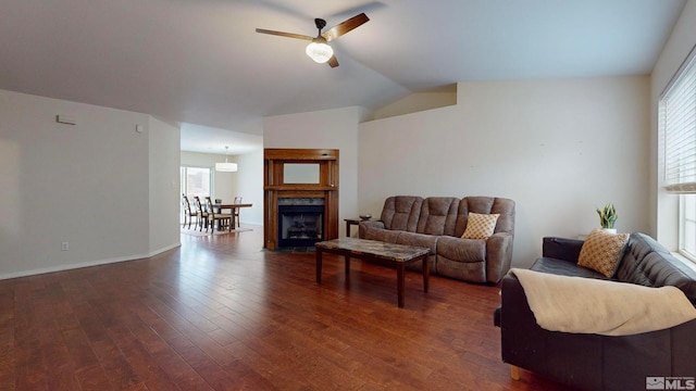 living room featuring ceiling fan, dark hardwood / wood-style flooring, and vaulted ceiling