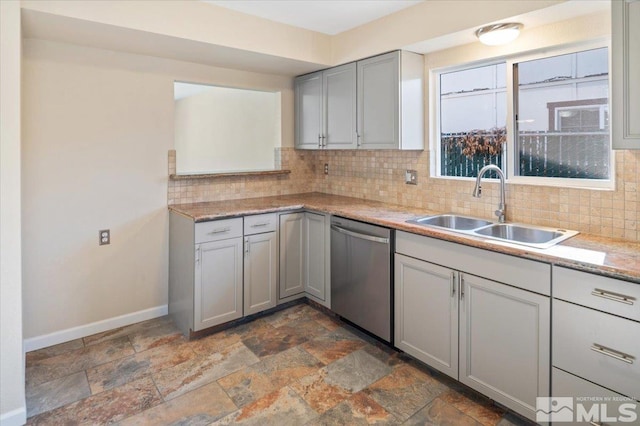 kitchen featuring stainless steel dishwasher, backsplash, gray cabinets, and sink