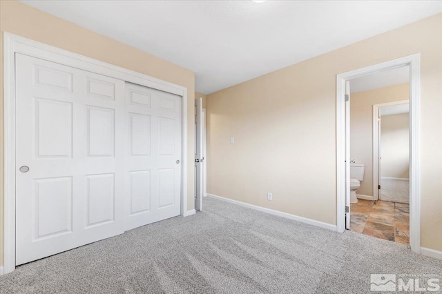 unfurnished bedroom featuring connected bathroom, a closet, and light colored carpet