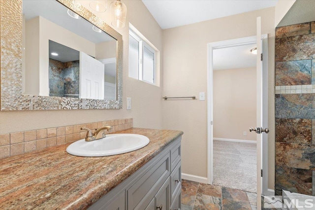 bathroom with tiled shower and vanity