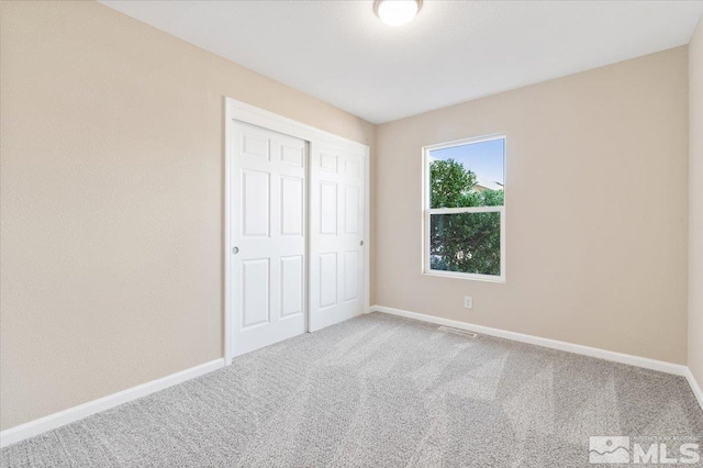 unfurnished bedroom featuring carpet floors and a closet