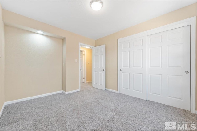 unfurnished bedroom with light carpet and a closet