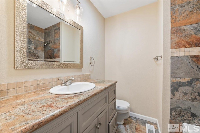 bathroom with walk in shower, vanity, and toilet