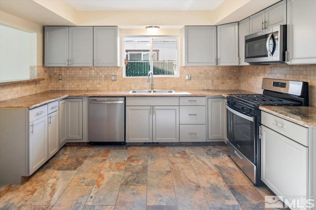 kitchen featuring gray cabinets, sink, and appliances with stainless steel finishes