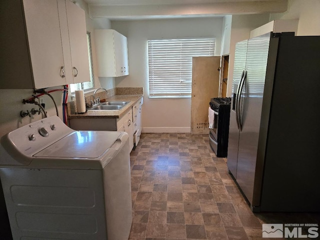 kitchen with washer / dryer, stainless steel appliances, white cabinetry, and sink