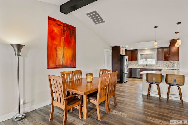 dining area with lofted ceiling with beams and dark wood-type flooring