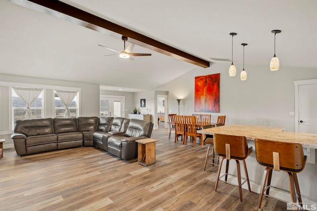 living room featuring light wood-type flooring, lofted ceiling with beams, and ceiling fan