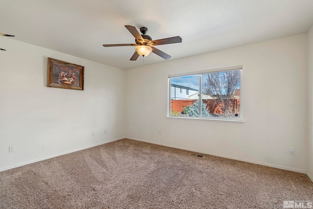 carpeted spare room featuring ceiling fan